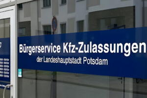 Ein blaues Schild an einer Glastür mit der Aufschrift Bürgerservice Kfz-Zulassungen der Landeshauptstadt Potsdam" kennzeichnet die Zulassungsstelle Potsdam für die Kfz-Zulassungen der Bürger, einschließlich der Dienstleistungen für die Kreise TF und LDS.